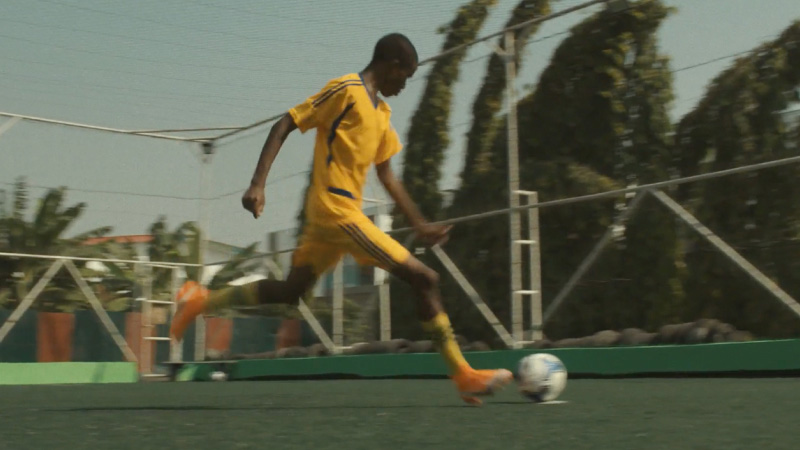 A soccer player dribbles the ball on the field